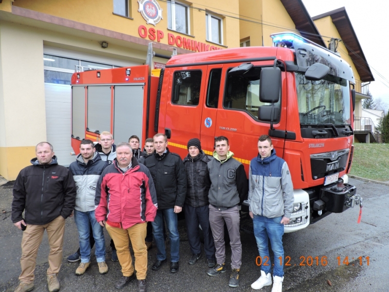 Ludzie pozują z wozem strażackim