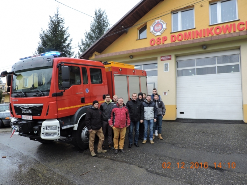 Ludzie pozują z wozem strażackim